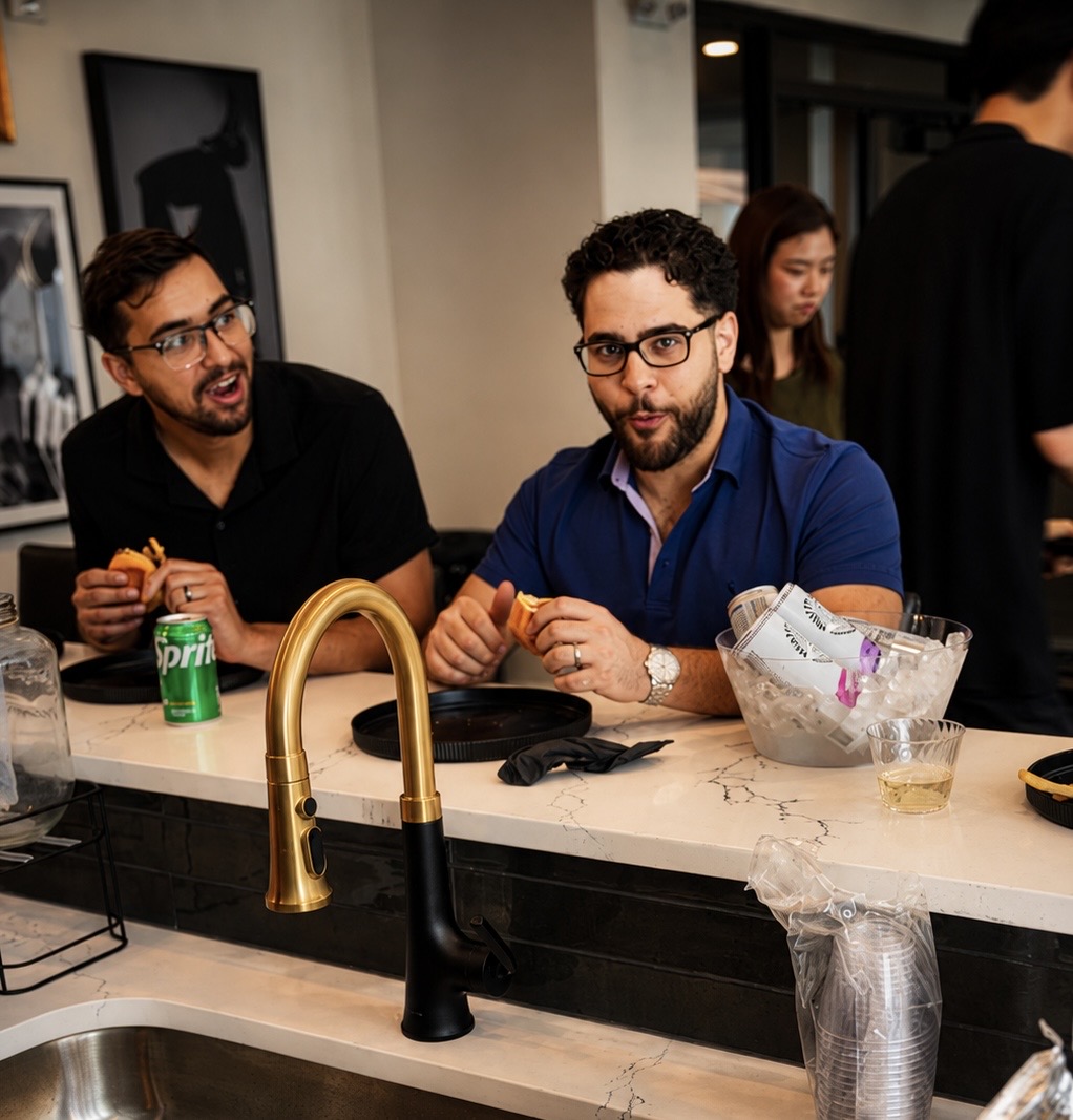 Two guests sharing Wagyu sliders at the counter